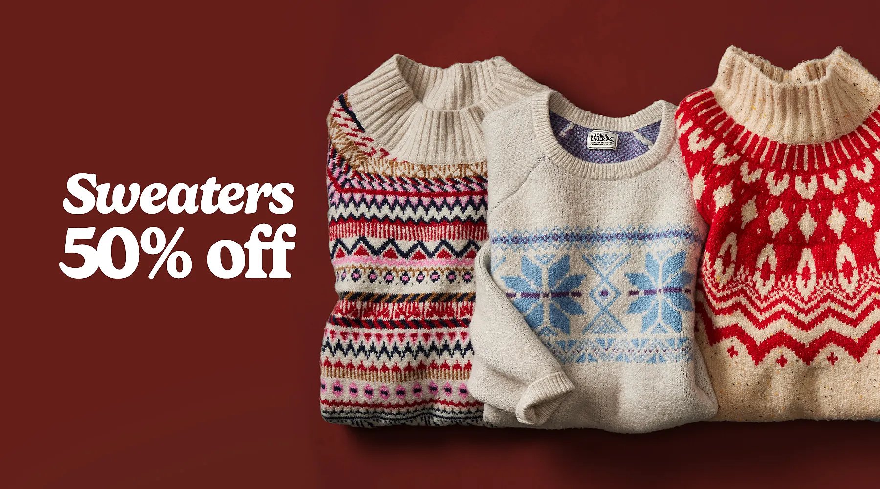 50% off sweaters. A row of folded holiday sweaters in different colors & patterns.
