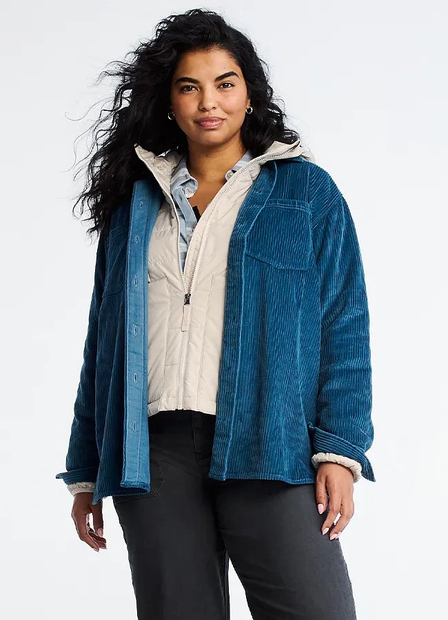 A women wearing a shirt jacket over a lightweight down jacket.