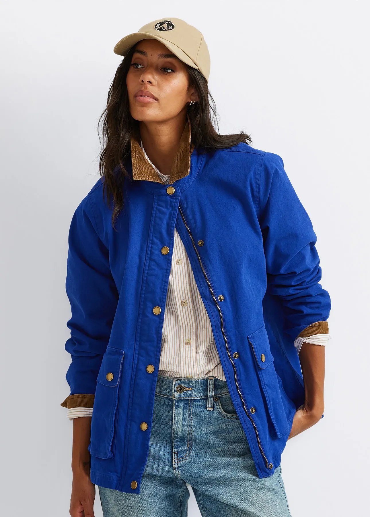 A woman wearing a baseball cap and a canvas barn jacket.