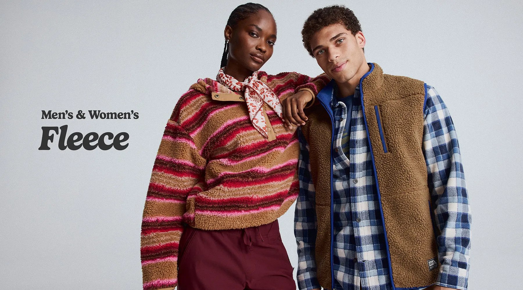 Men’s & women’s fleece. A woman wearing a fleece pullover and a man wearing a fleece vest over a flannel shirt.