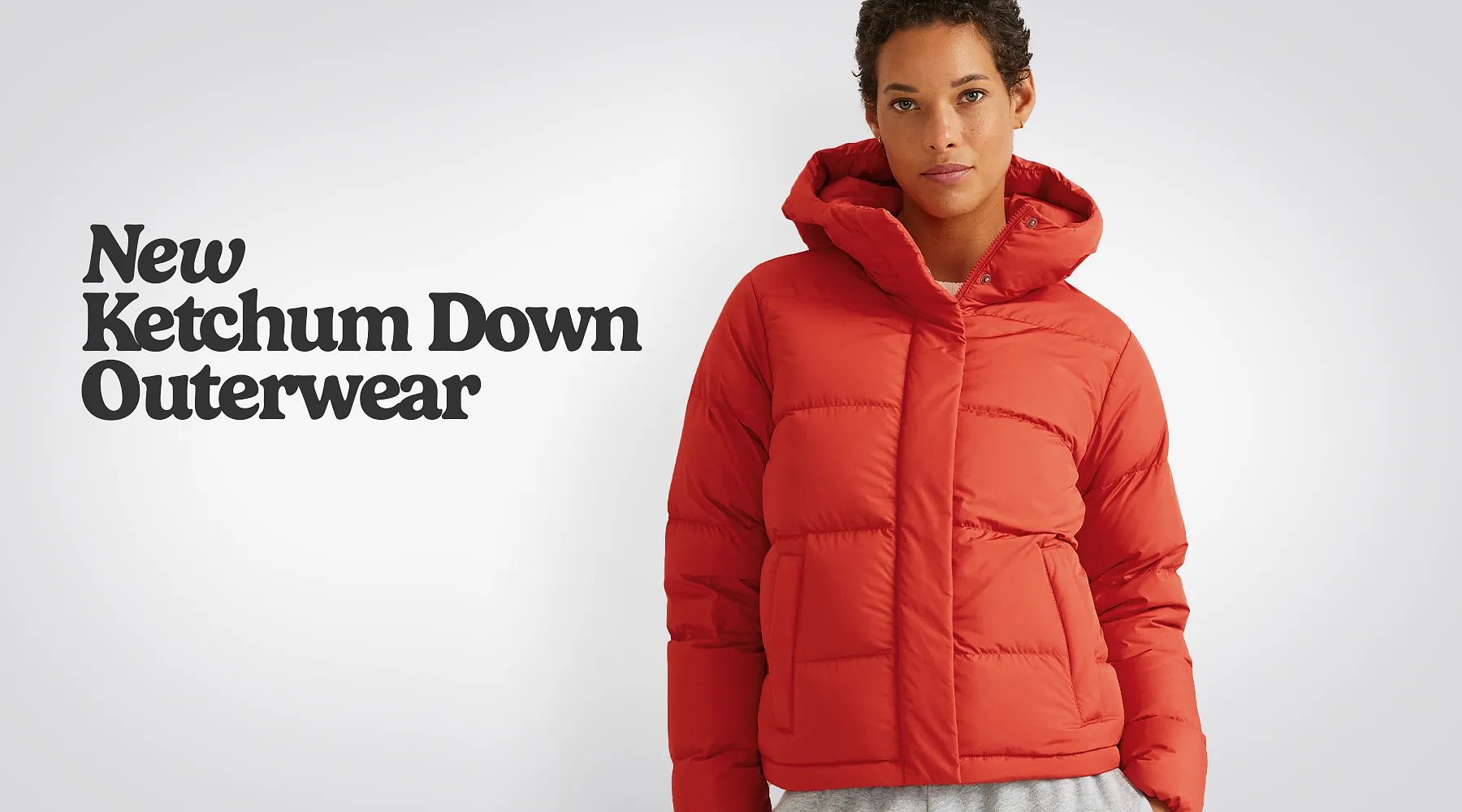 New Ketchum Down Outerwear. A woman holding a pair of skis wears a Ketchum Down Jacket & down mittens.