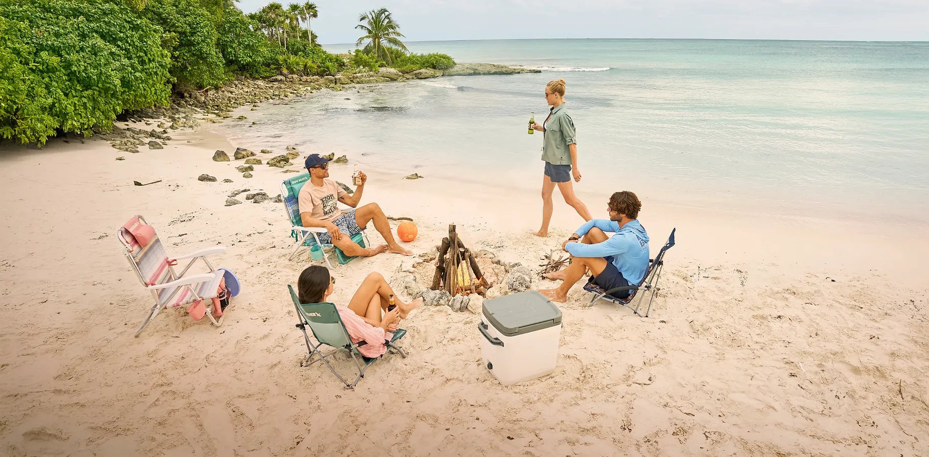 A group of friends having a camp fire on a beach