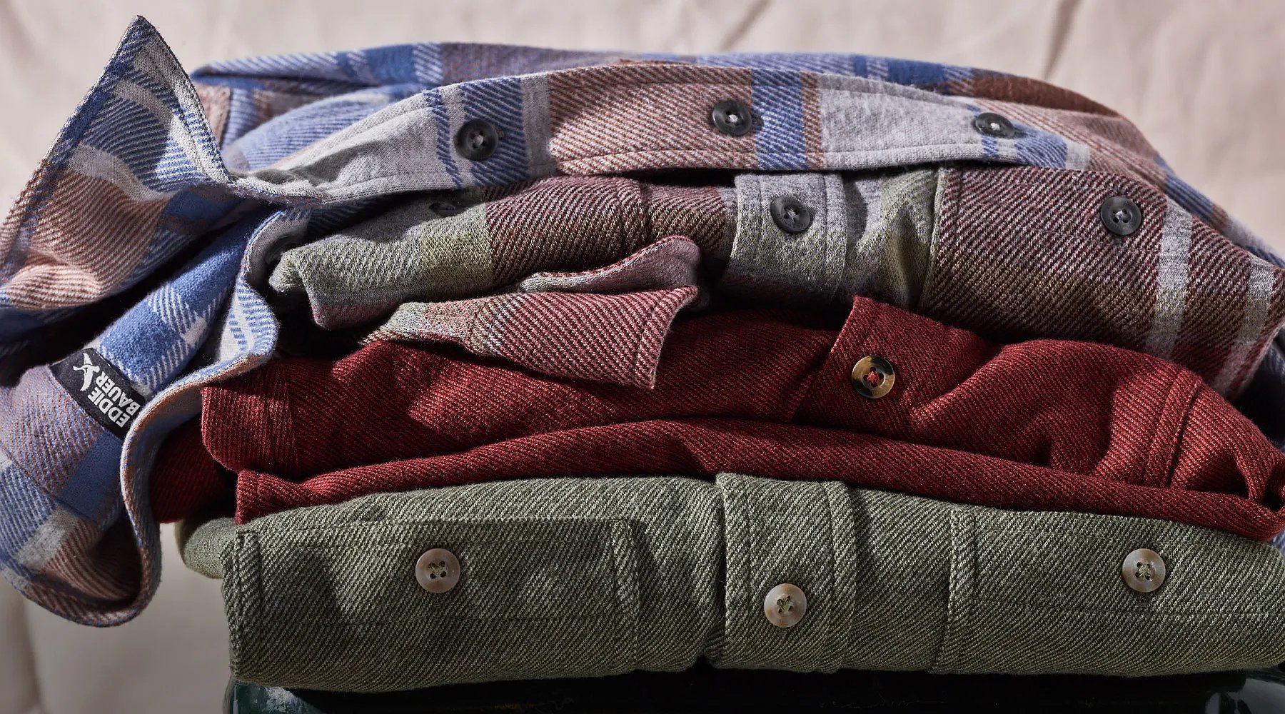 A stack of flannel shirts in different colors and patterns.