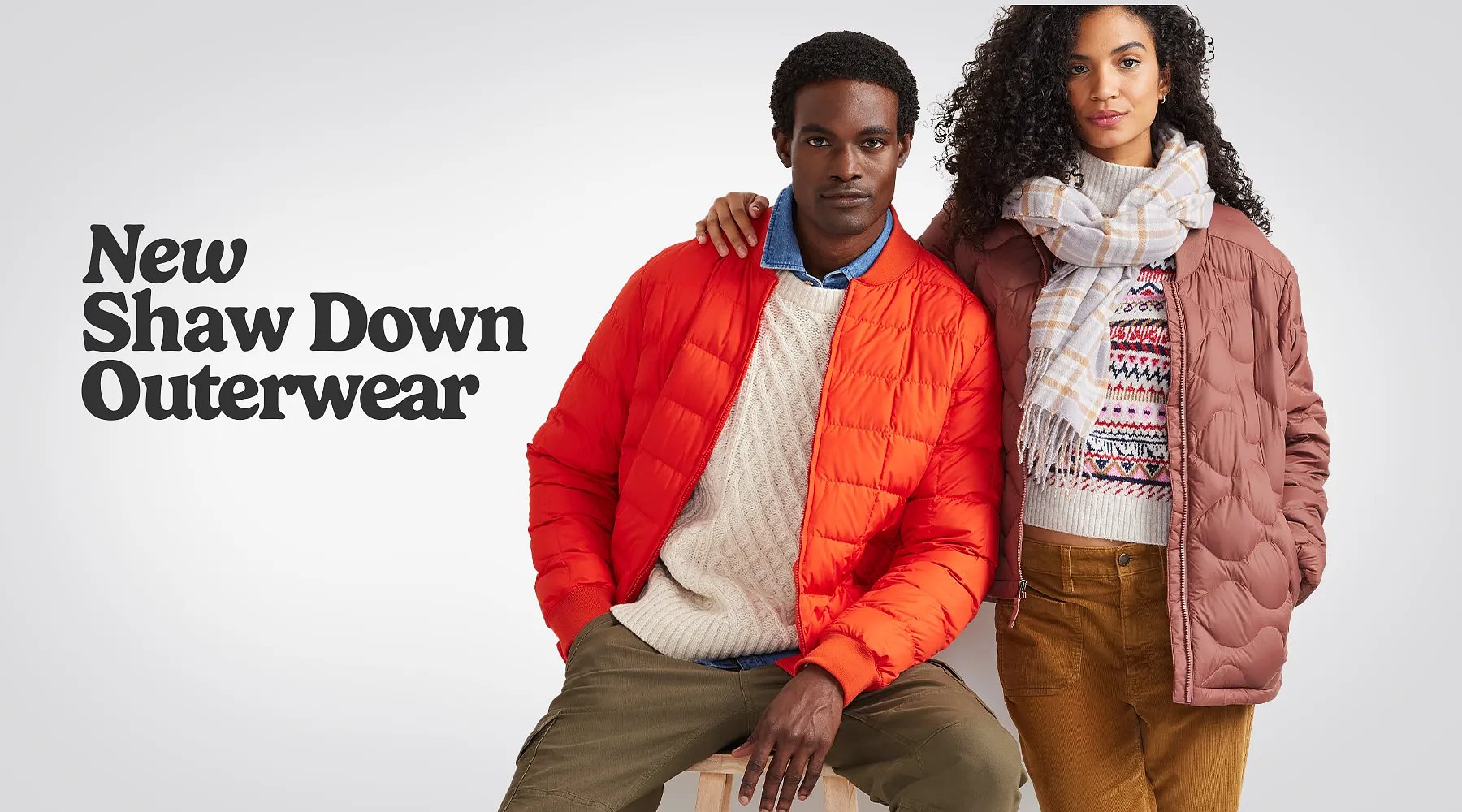 New Shaw Down Outerwear. A man wears a Shaw Down Bomber Jacket over a sweater and a woman wears a Shaw Down Parka and a scarf over a sweater.