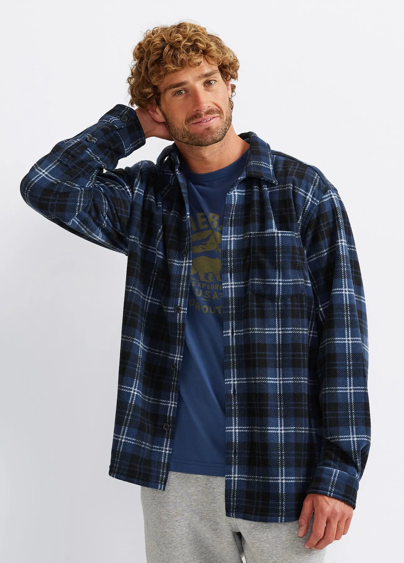 A man wearing sweats and a short-sleeve tee layered over a long-sleeve tee.